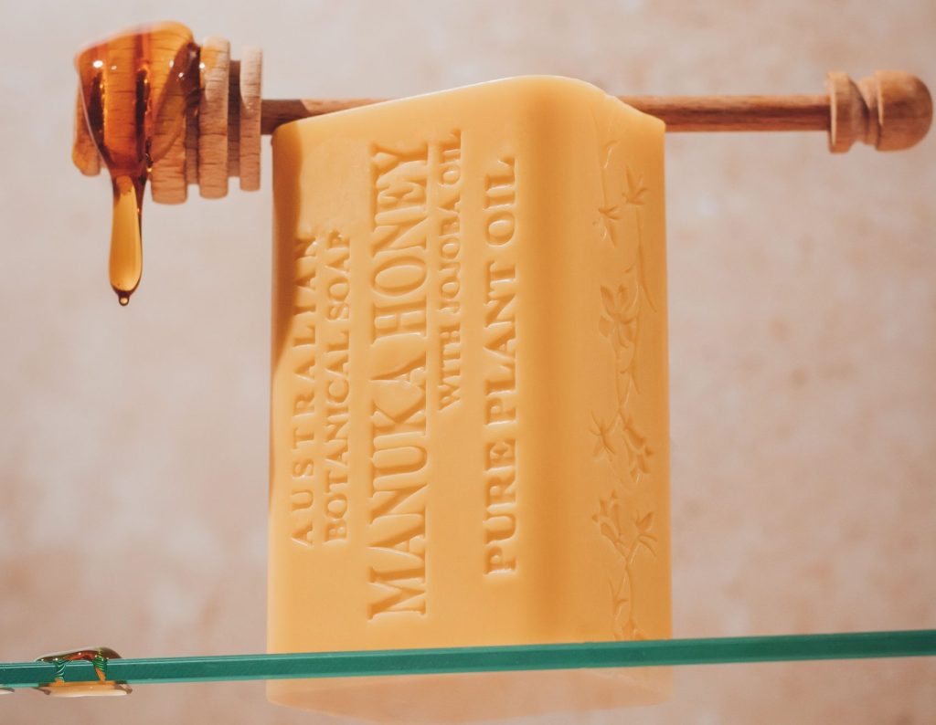 Australian Botanical Soap Manuka Honey with Jojoba Oil natural soap bar with a honey dipper, a sweet-scented pairing for a natural bathroom routine